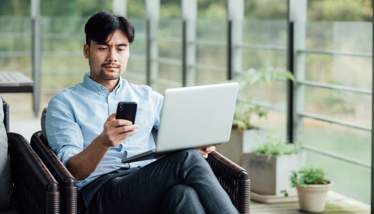 asian-businessman-using-laptop-at-office-window-2021-08-28-14-47-40-utc