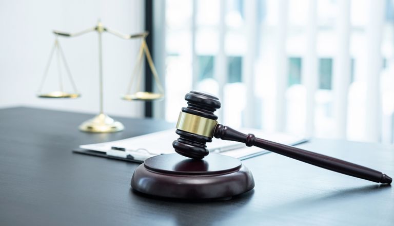 judge-gavel-with-justice-at-law-firm-in-background-2021-10-16-17-40-19-utc